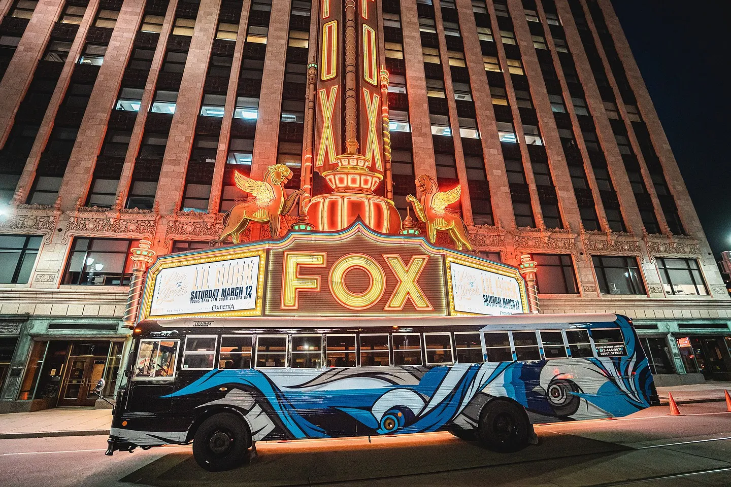 Belle the hand-painted Art Bus under the glowing Fox Theatre marquee at night