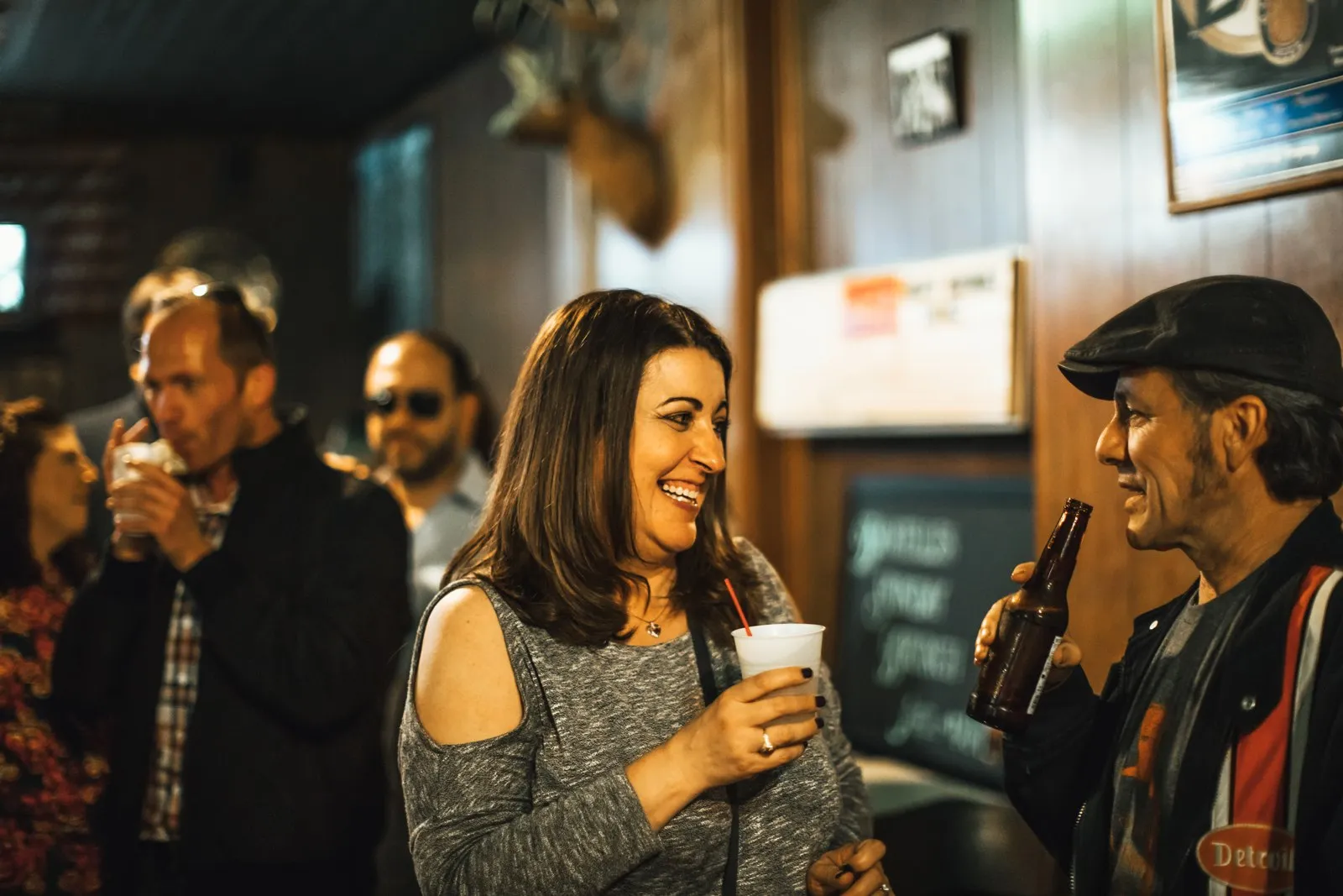A guest laughing with others inside one of the historic bars