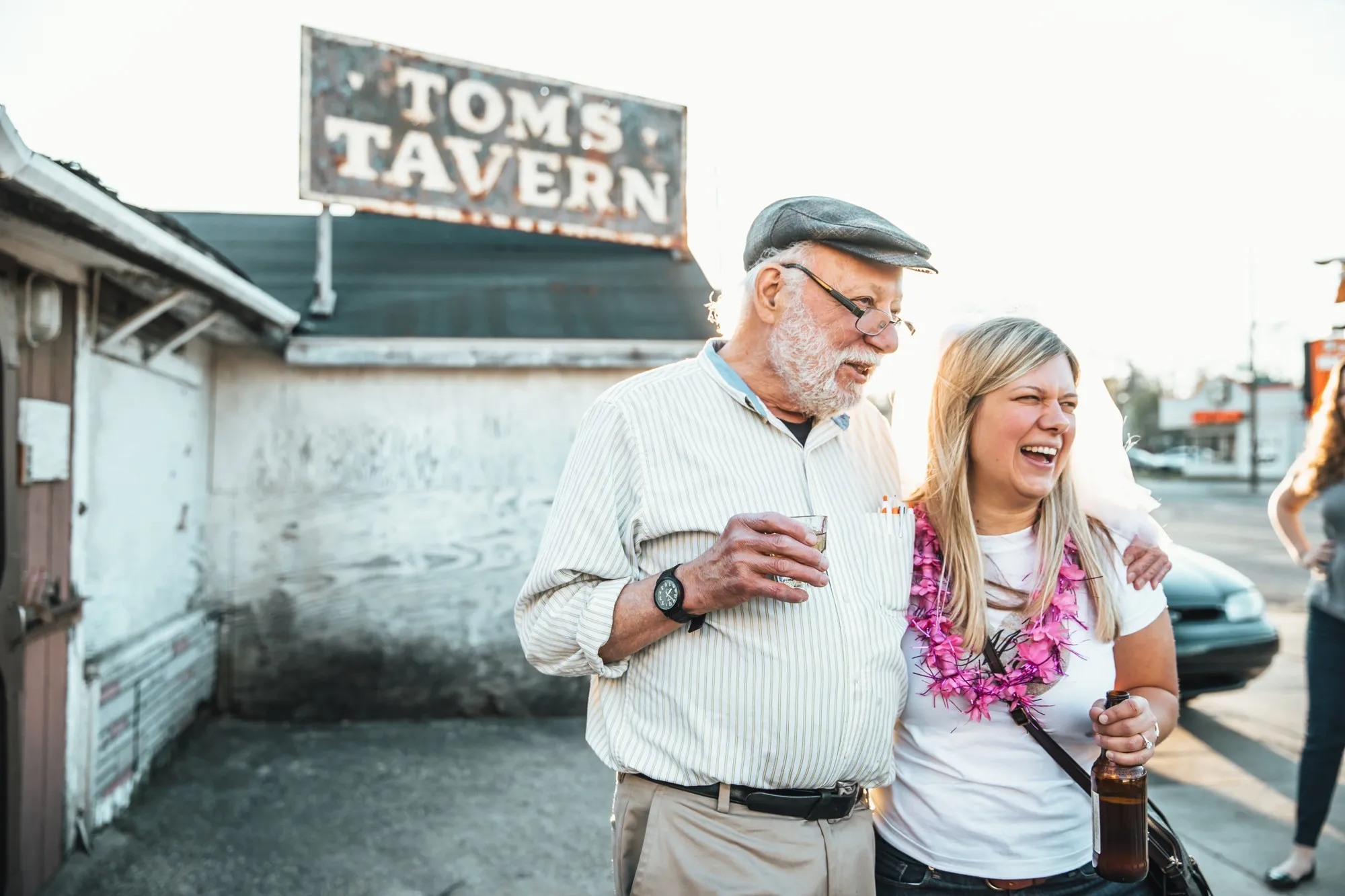 Two tour guests laughing under the Tom's Tavern sign on Drunks of Antiquity