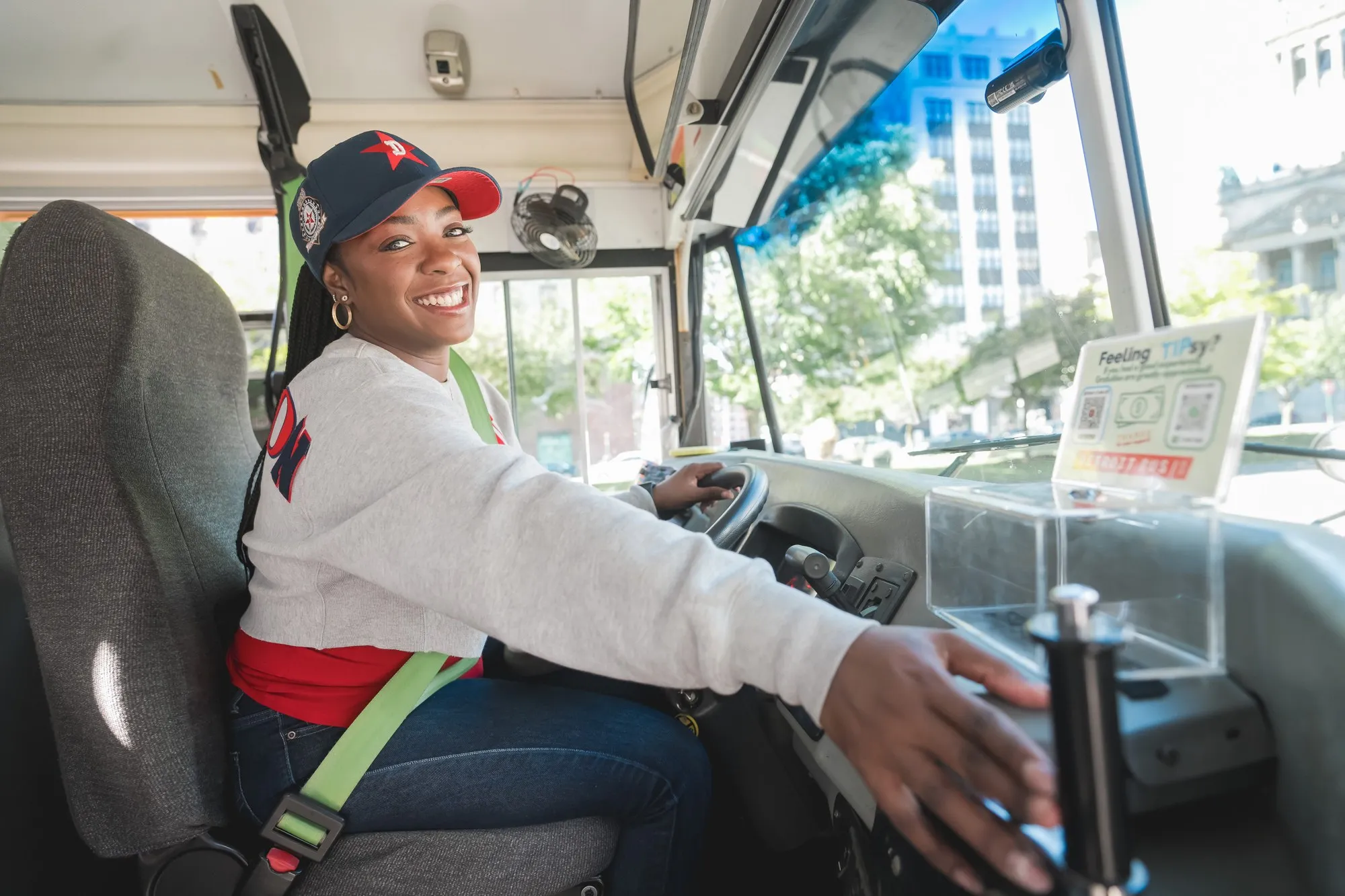 A smiling Detroit Bus Company driver at the wheel