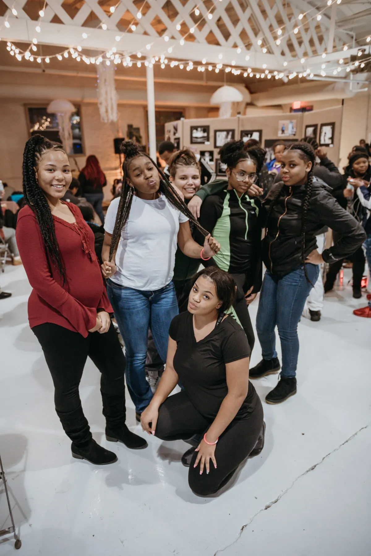 A group of teens smiling together at a youth art showcase