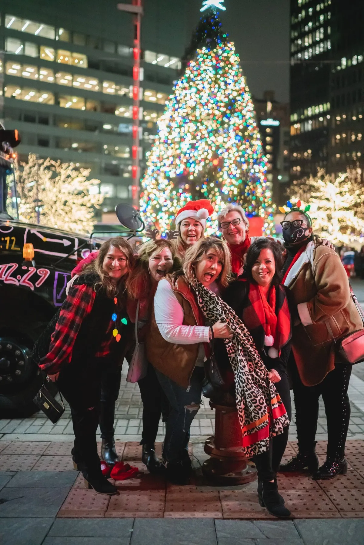 A group posing in front of downtown Detroit's giant Christmas tree