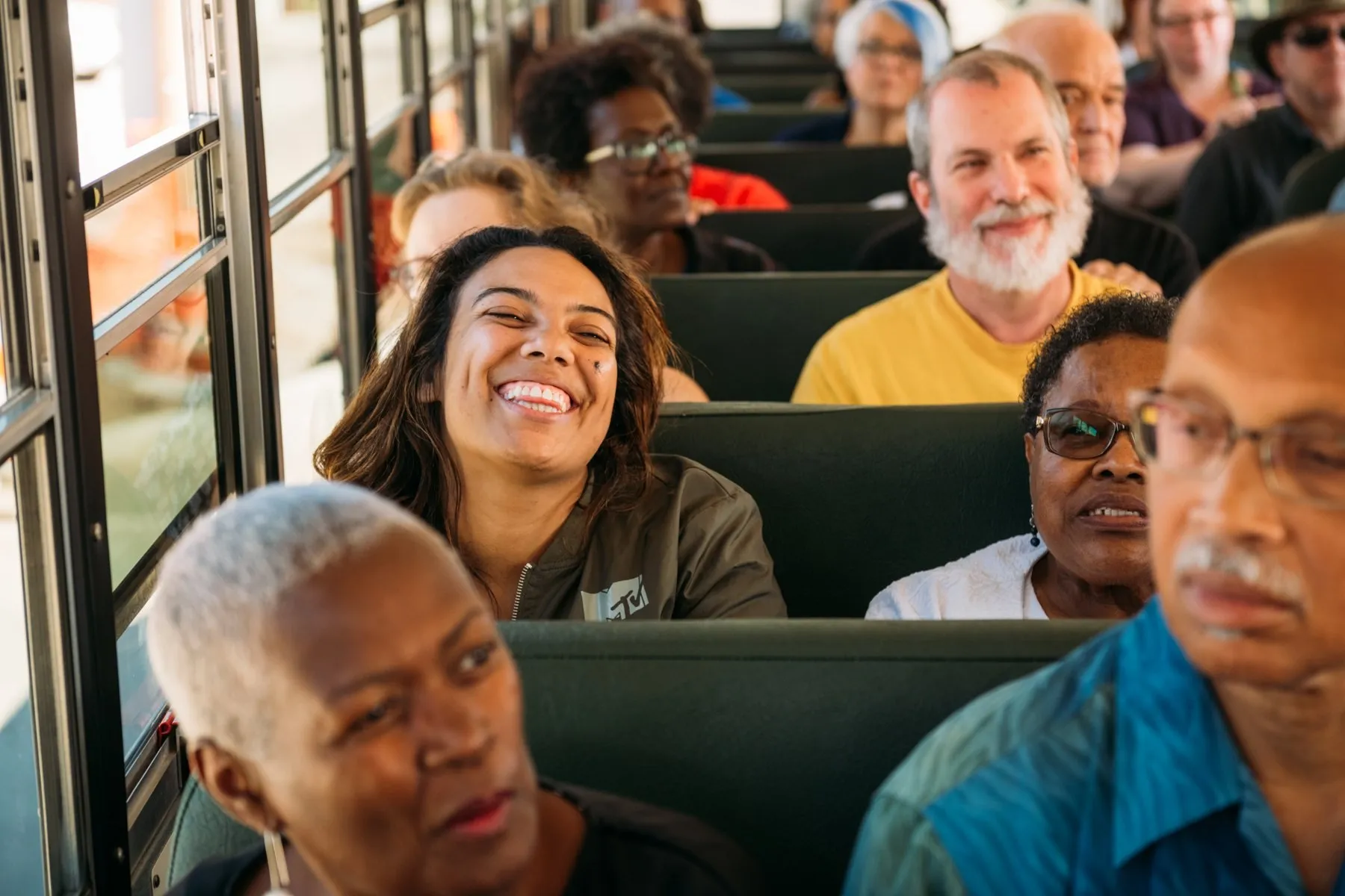 A rider mid-laugh in a busload of happy people