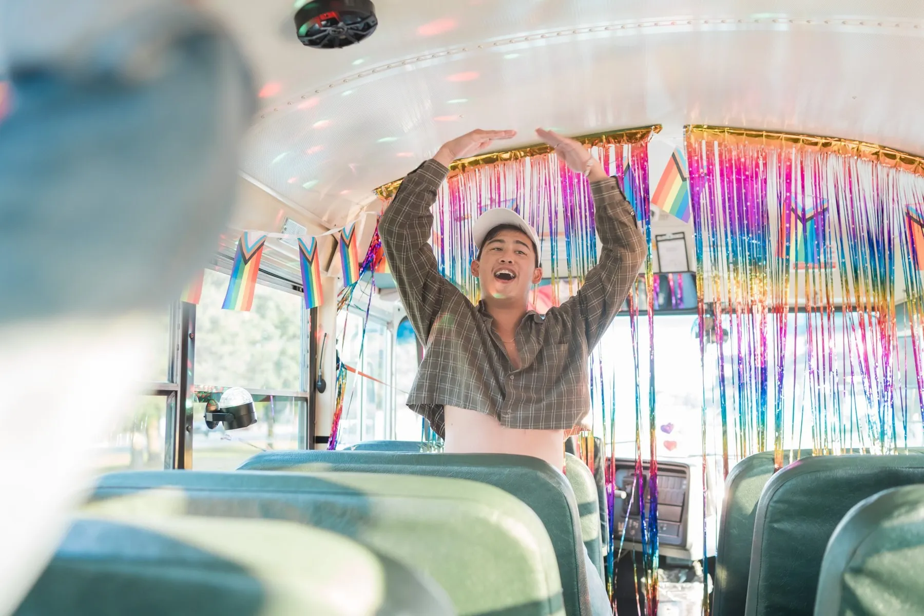 A rider dancing under the tinsel-decked ceiling of the bus